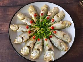 把蒸好的鱼取出，倒掉蒸出来的水，重新放入香葱加入1勺的蒸鱼豉油，淋上热油即可。