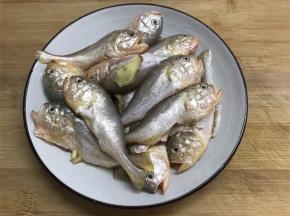 把买回来的梅子鱼去掉腮和内脏，清洗干净后放入少许的盐和料酒腌制10分钟。