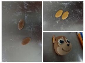 分别切两个椭圆的可可面团和橘色面团，作为阿奇的耳朵，如图粘好，把眼睛鼻子都粘好