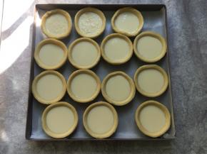 搅拌好的蛋挞液过筛一遍，会更细腻，倒入蛋挞皮八分满，有两个是加了马苏里拉芝士的