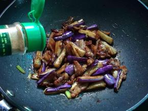 加入茄子和五花肉翻炒，再调入料酒、老抽、生抽、五香粉