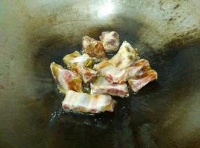 锅里放入少许食用油，倒入排骨翻炒。
