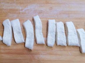 用锋利的刀切成约2厘米左右的条！切好的面团盖上保鲜膜松弛几分钟，这样做出来的油条更松软！