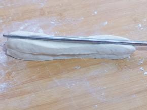 取两条面捏在一起，用一根筷子放在条状面团的中间，压出印记，压悄悄深一点！压好一面再反过来压痕迹！（两面都要用筷子压出印记）