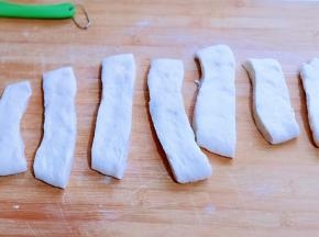 第二天早上把面团取出放室温回温，再将取出面团排气，松弛10分钟，用擀面杖擀成面片，约1厘米厚！切出12条！