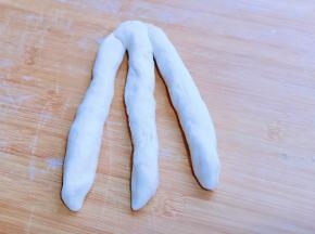 取3条面团，用掌心搓圆拉长，将三条面团顶部捏紧。