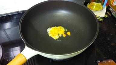 不粘锅里热油，放入蛋黄碎煮至起泡