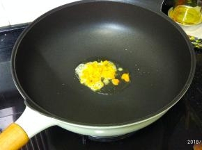 不粘锅里热油，放入蛋黄碎煮至起泡