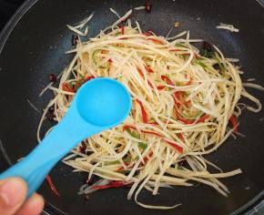 然后放一勺醋翻炒均匀。第二勺醋的主要作用就是润锅，防止土豆丝烧糊粘锅，同时让土豆丝酸得更有内涵