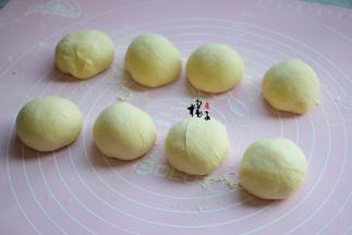 取出来面团，揉出气泡，把面团平均分成8份，并且滚圆每个小面团，为了容易整理面包形状，可以盖保鲜膜静置10分钟