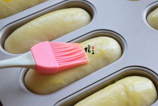 放烤箱，二次发酵25分钟，大概九分满就可以了，取出来，刷一层鸡蛋液，再撒点芝麻