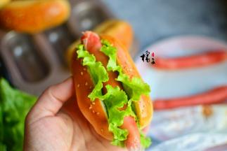 把面包中间切开，但是不要切断，把生菜放中间，再放一个火腿肠或者香肠，挤上沙拉酱即可食用