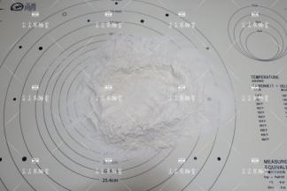 面粉混合物倒在面板上，中间挖一个窝