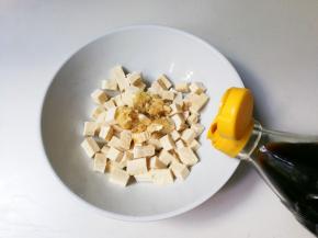 碗中放入蒜泥，一勺生抽