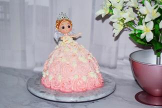 插到蛋糕中间，把娃娃身体部分到肩膀用细裱花嘴挤出裙子上衣，再不规则的撤上彩色糖珠装饰即可