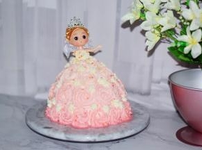 插到蛋糕中间，把娃娃身体部分到肩膀用细裱花嘴挤出裙子上衣，再不规则的撤上彩色糖珠装饰即可