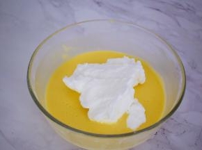 先把三分之一的蛋白霜放入蛋黄中，翻拌均匀