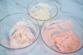再把剩余的淡奶油打发至裱花状态，分成4份，一份白色的放入冰箱冷藏备用，其它三份分别加入红色色素，由深至浅调好