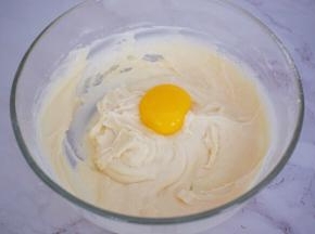 再加入蛋黄，一个一个加入，再拌均匀