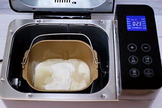 面包桶里加入称重的面粉，酵母和清水，没有面包机的亲们，可以直接用手和面。