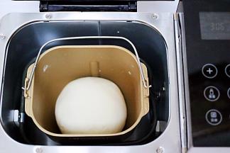 启动面包机，一个和面过程后，用手把面团揉圆，放到面包机里开始醒发。