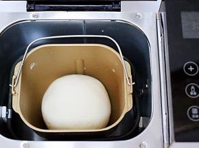 启动面包机，一个和面过程后，用手把面团揉圆，放到面包机里开始醒发。