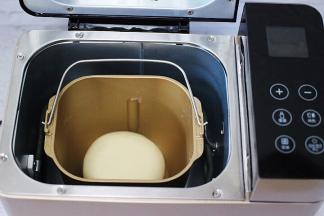 打开电源启动面包机和面一个程序，和好的的面用手揉圆后，再放入面包机里，盖上盖子开始醒发。