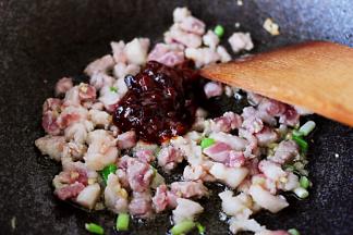 翻炒至猪肉变色时，加入黄豆酱进行小火翻炒。