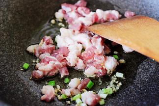 锅中放入切丁的猪肉进行翻炒。