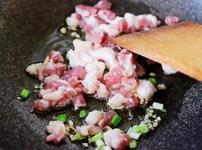 锅中放入切丁的猪肉进行翻炒。