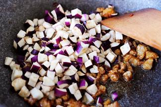 加入切丁的茄子，然后再继续中火进行翻炒。