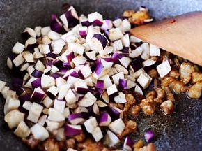 加入切丁的茄子，然后再继续中火进行翻炒。