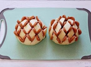 在馒头的切开的缝隙里，均匀地夹入火腿肠。