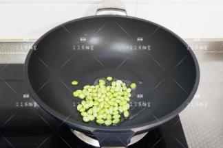 起锅热油，加入毛豆仁翻炒出香味
