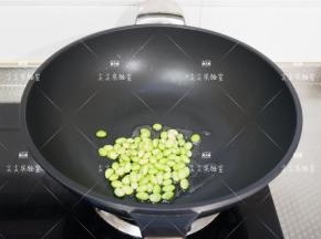起锅热油，加入毛豆仁翻炒出香味