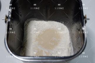 按照先液体，中层面粉，最后酵母的顺序投入面包机桶内，混着揉成光滑的面团
