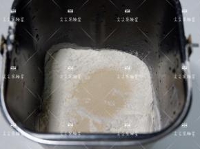 按照先液体，中层面粉，最后酵母的顺序投入面包机桶内，混着揉成光滑的面团