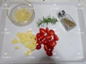 大蒜切成碎末与30克橄榄油混合拌匀，土豆切成小片，小番茄对半切开