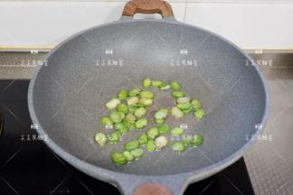起锅热油，先加入蚕豆瓣翻炒出香味，微微焦一点那样