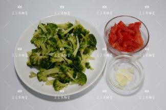 西兰花摘成小朵焯水后沥干备用，番茄切小块，大蒜切片