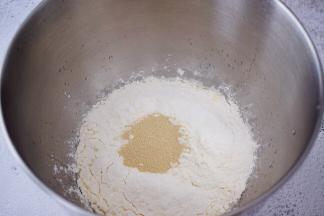 将除了黄油外所有的材料全放入海氏厨师机的和面桶中，按照先液体后固体的顺序放入，最上面放酵母，启动揉面程序