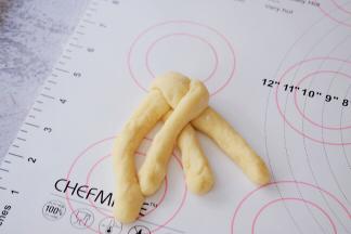 取一个面团揉成长条状，2个为一组，辫成三股辫子