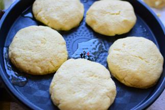 用刮板轻轻把饼胚托起来，放在电饼铛里，盖上锅盖