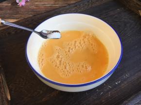 将鸡蛋磕入碗中打散，放入少许（适量）的盐，搅拌均匀。