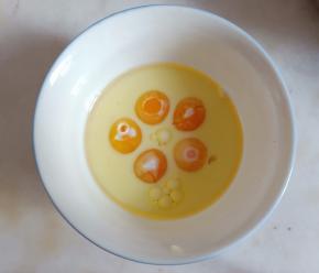 蛋黄中加入玉米油和纯牛奶。