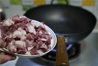 在原味铁锅里加入适量油，微热之后将猪肉丁下锅炒至微酥出油。然后再将藕丁下锅同炒至出味。
