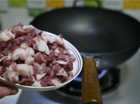 在原味铁锅里加入适量油，微热之后将猪肉丁下锅炒至微酥出油。然后再将藕丁下锅同炒至出味。