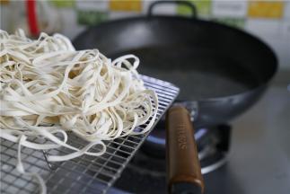 蒸好酱丁之后，就可以烧水煮面啦，原味铁锅里加水煮开，将面条下锅煮。