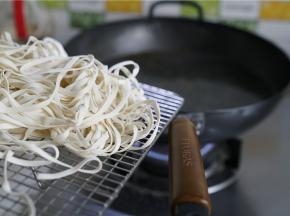 蒸好酱丁之后，就可以烧水煮面啦，原味铁锅里加水煮开，将面条下锅煮。