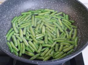 买回来的刀豆去根，去尖，再掰段，长短依个人喜欢，用冷水冲洗两遍，之后焯水，锅中加入清水烧开，下处理好的刀豆，加入2g食用盐，几滴食用油！